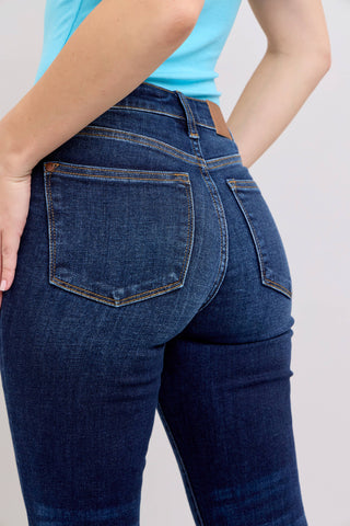 Person wearing blue jeans with a plain background