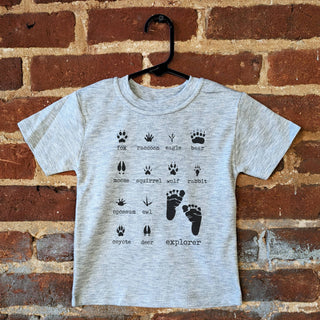 Gray t-shirt with animal prints and text on a brick wall background