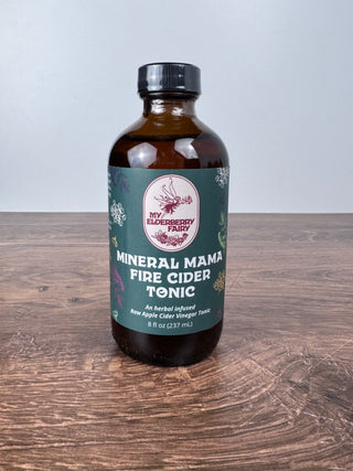 Bottle of 'Mineral Mama' Fire Cider Tonic on a wooden surface