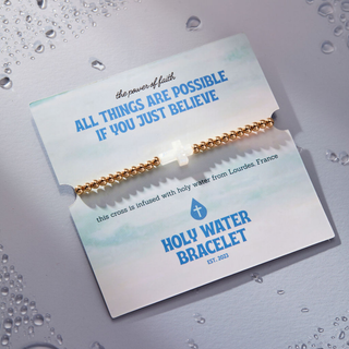 Holy Water Stretch Bracelet in yellow gold with waterproof brass beads and resin cross infused with holy water from Lourdes, France | JSQ Mercantile – Women’s Boutique & Gift Shop in La Grange, IL